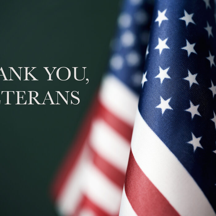 american flags and the text thank you veterans against a dark green background