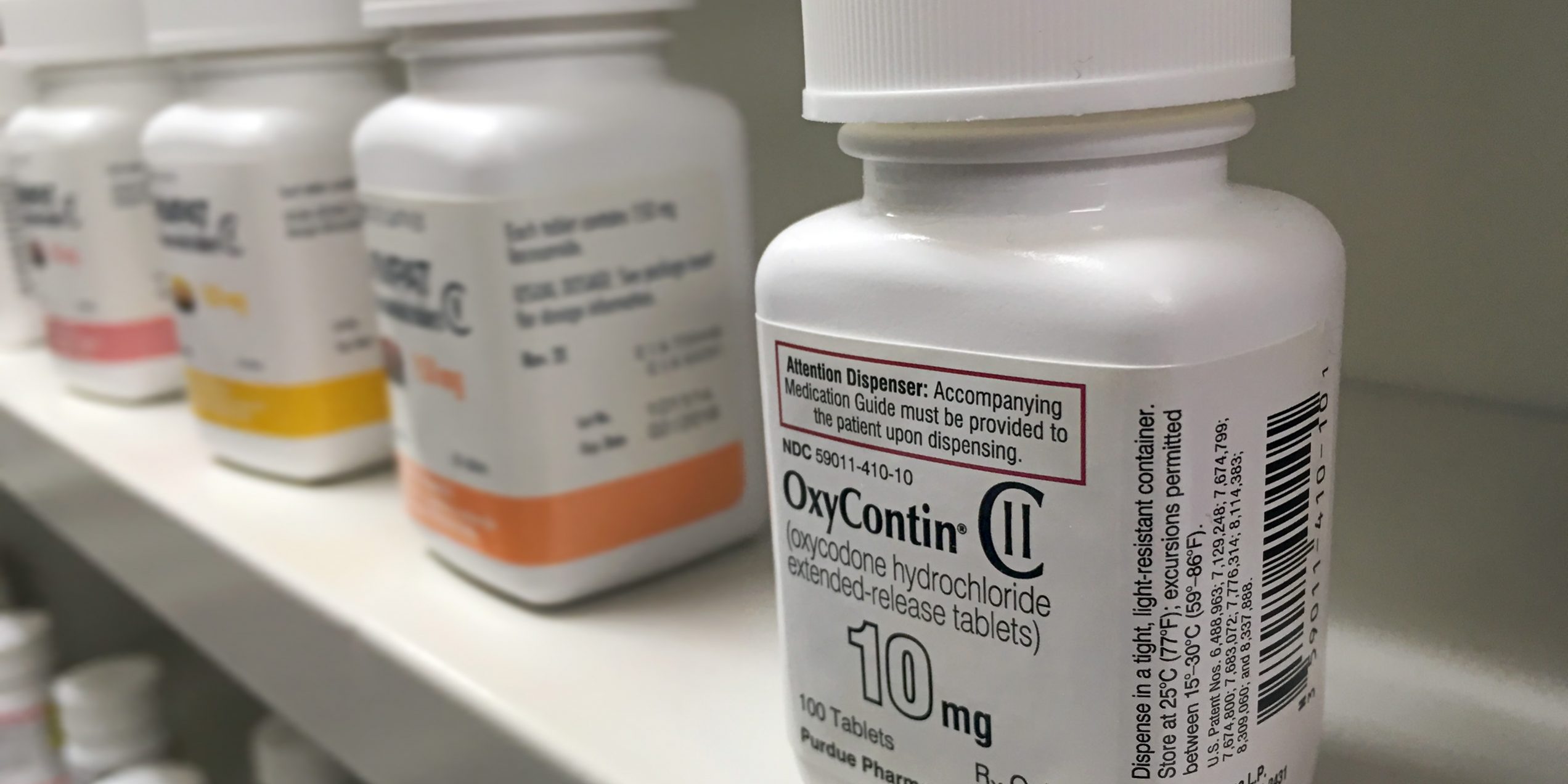 Oxycontin abuse illustration with pill bottles of oxycontin lined up on a shelf