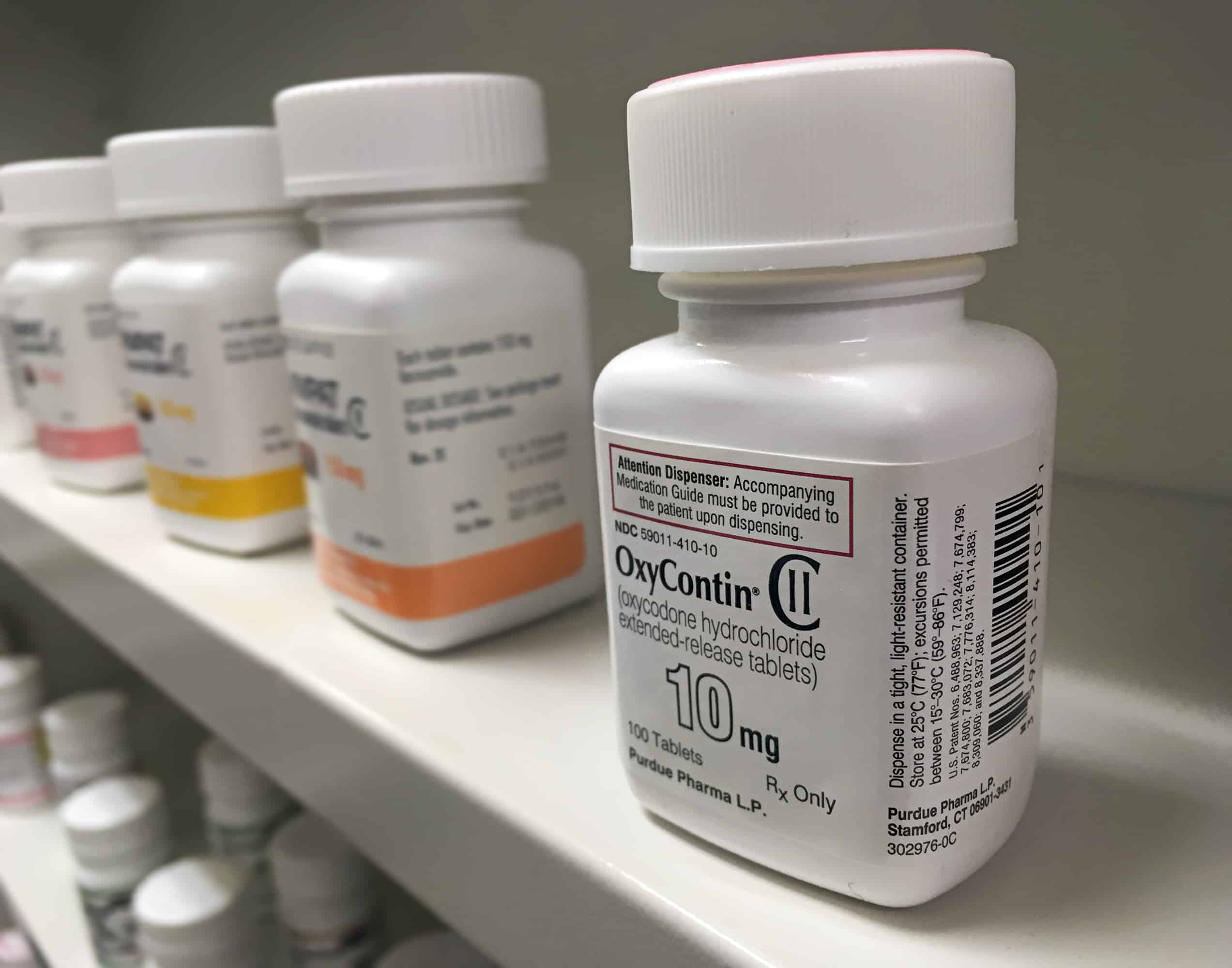 Oxycontin abuse illustration with pill bottles of oxycontin lined up on a shelf
