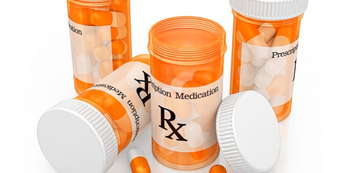 Prescription Painkiller bottles with some pills on the table