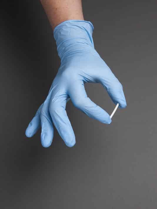 implant being held by hand with gloves