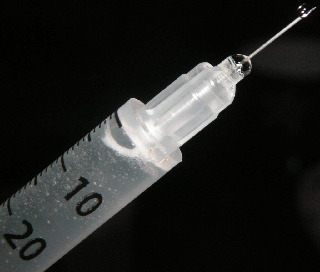 A needle with liquid squirting out - illustration for Heroin injection sites post