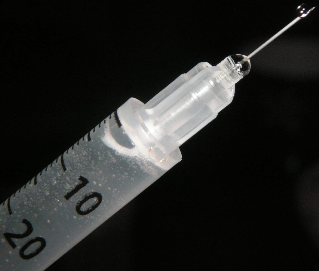 A needle with liquid squirting out - illustration for Heroin injection sites post