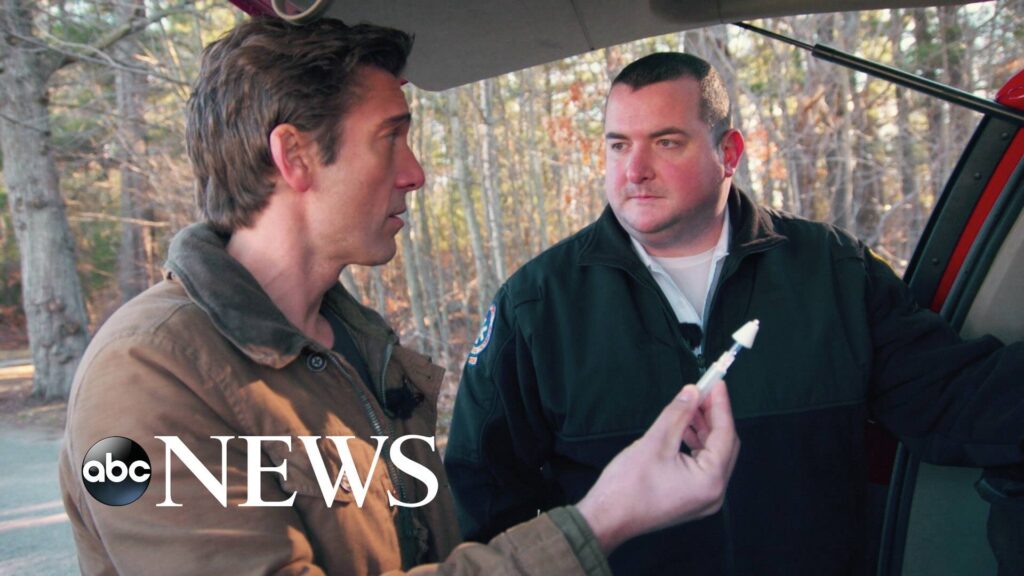 abc News logo on image of man holding syringe next to another man at the back of a vehicle.