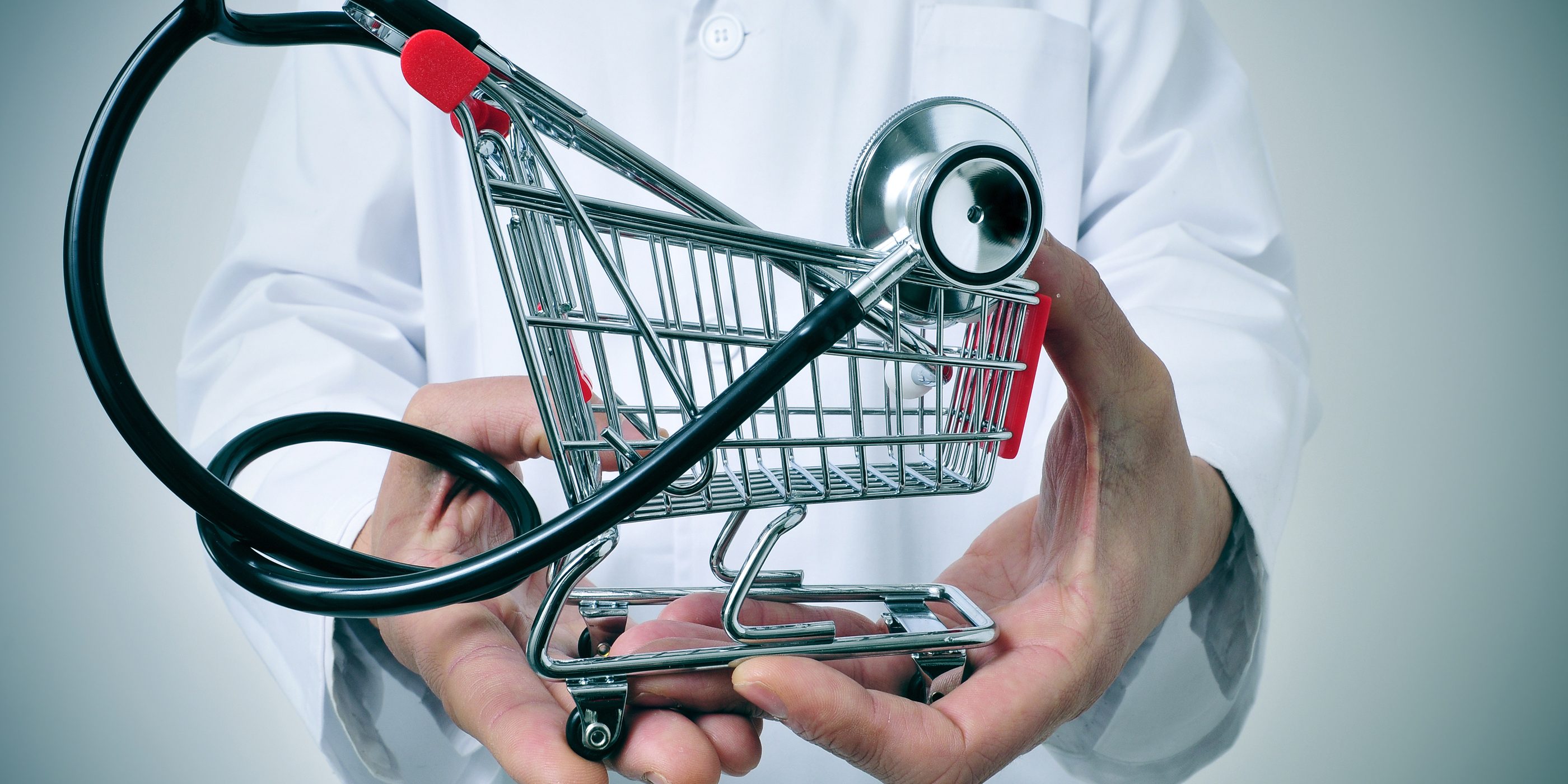 doctor holding in his hand a shopping cart with a stethoscope inside, depicting the health care industry concept