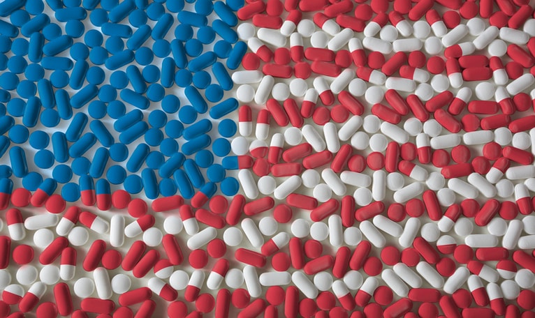 American flag depicting in red white and blue pills. This illustration is for the 24 facts on the history of opioids in america