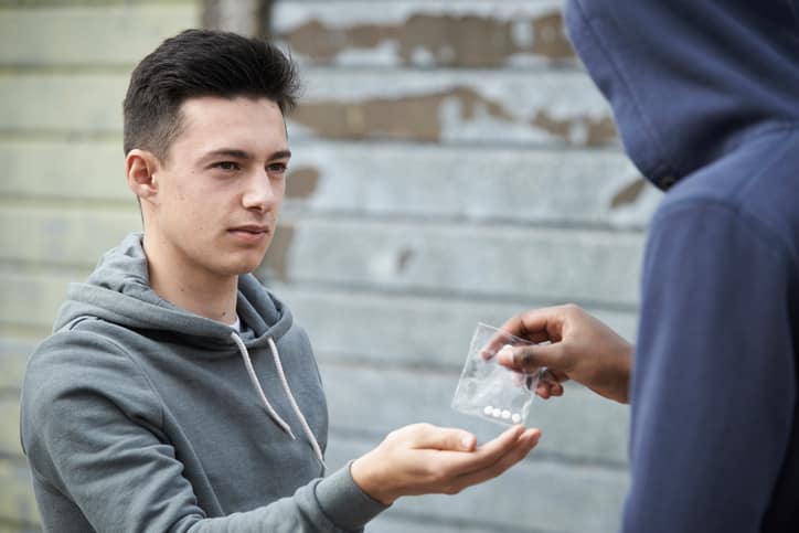 teenager getting drugs from male. Illustration for help teen overcome drug abuse article.