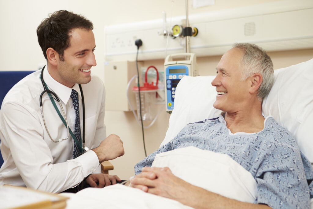 happy male patient receiving medical detox for alcohol dependence from a medical detox doctor in a hospital bed