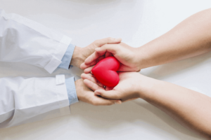 Doctor and patient holding a rubber heart - concept of comprehensive medical care vs one-day detox