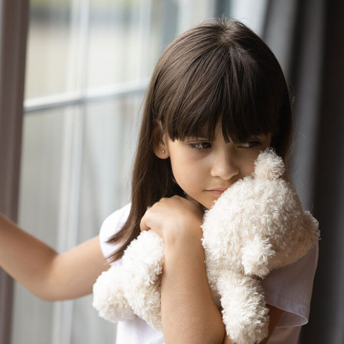 Sad lonely little girl holding, hugging teddy bear toy. Concept of Suboxone Addiction and Its Impact On Families