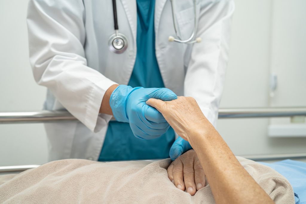 Closeup photo of doctor touching patient's hand, concept of fentanyl treatment in a hospital