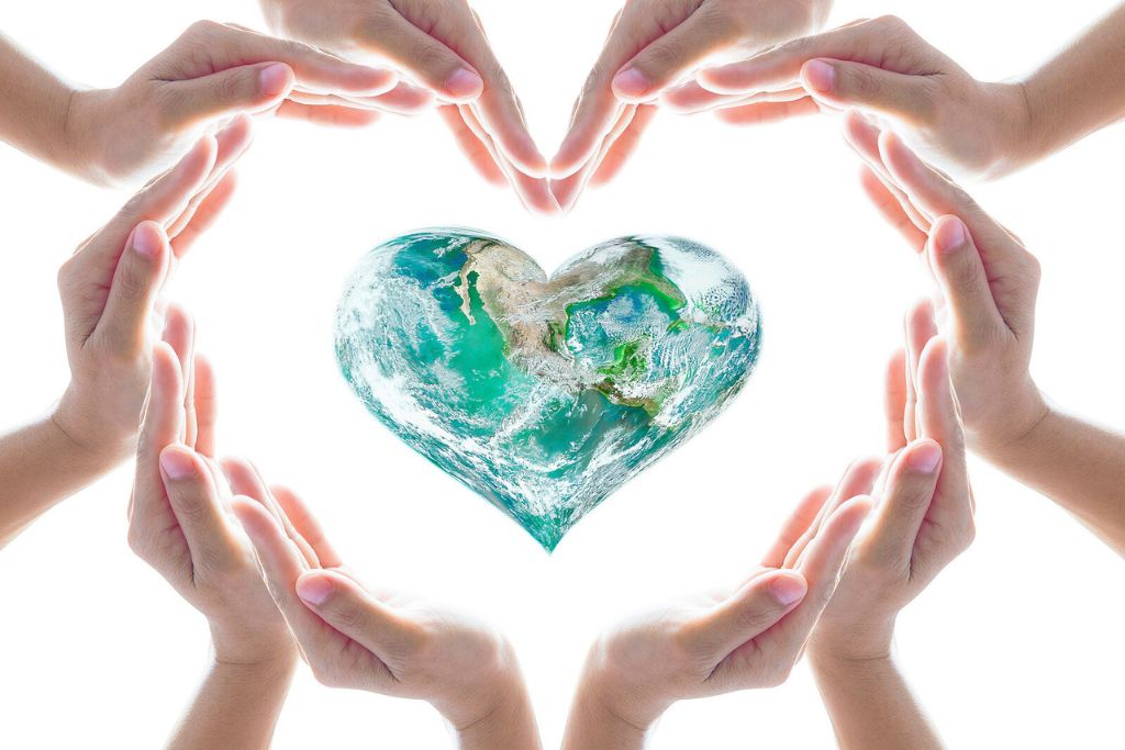 A photo of hands coming together in a shape of a heart around heart-shaped globe - concept of addressing the fentanyl crisis amidst modern challenges